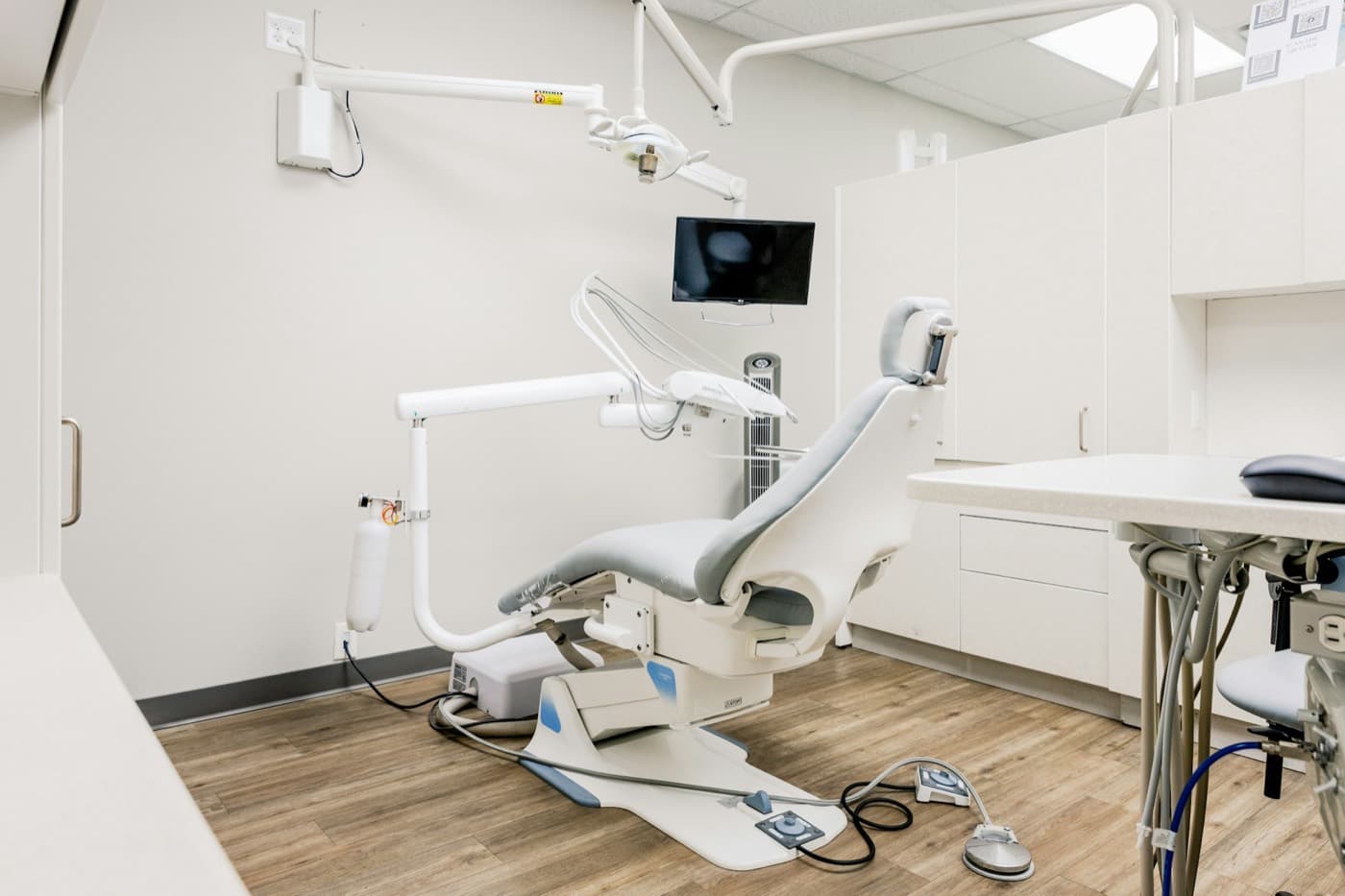 Sala clinica vazia com cadeira odontologica e equipamento montado